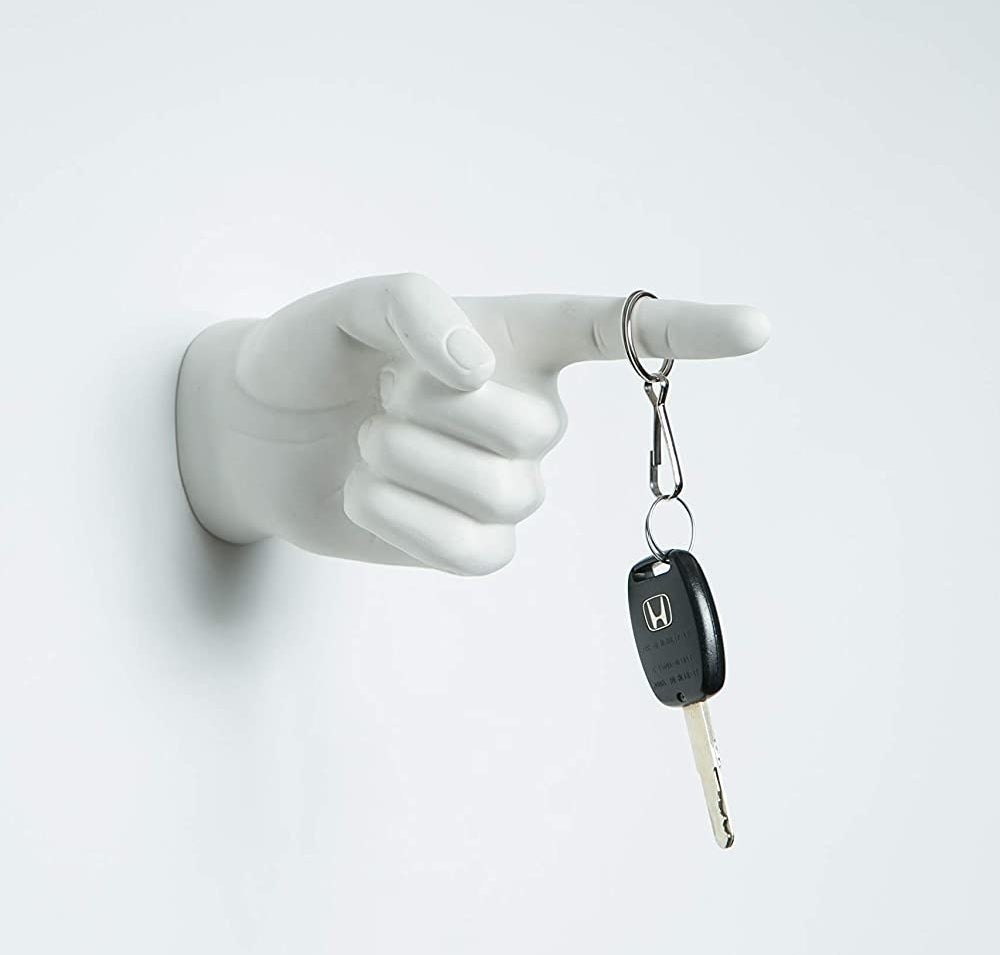 A wall-mounted hand with a finger sticking out to hold hanging objects