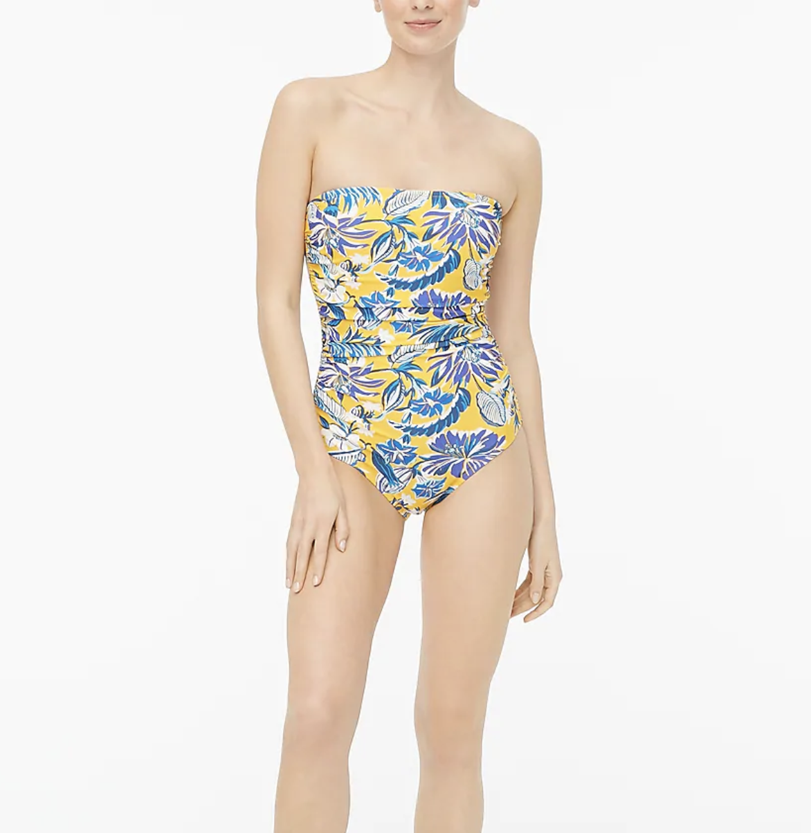 A model wears a  strapless one-piece swimsuit in a floral yellow print