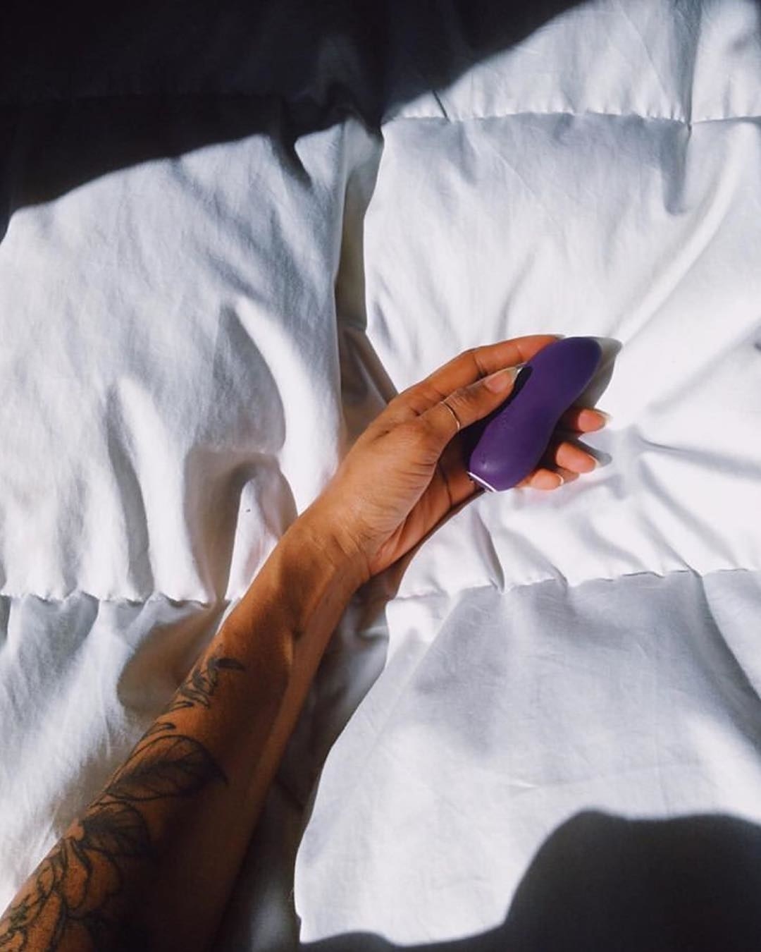 Model holding the finger-shaped vibrator that&#x27;s about the size of their palm