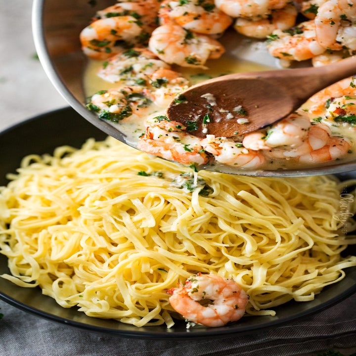 A bowl of spaghetti being tossed with garlicky shrimp scampi.