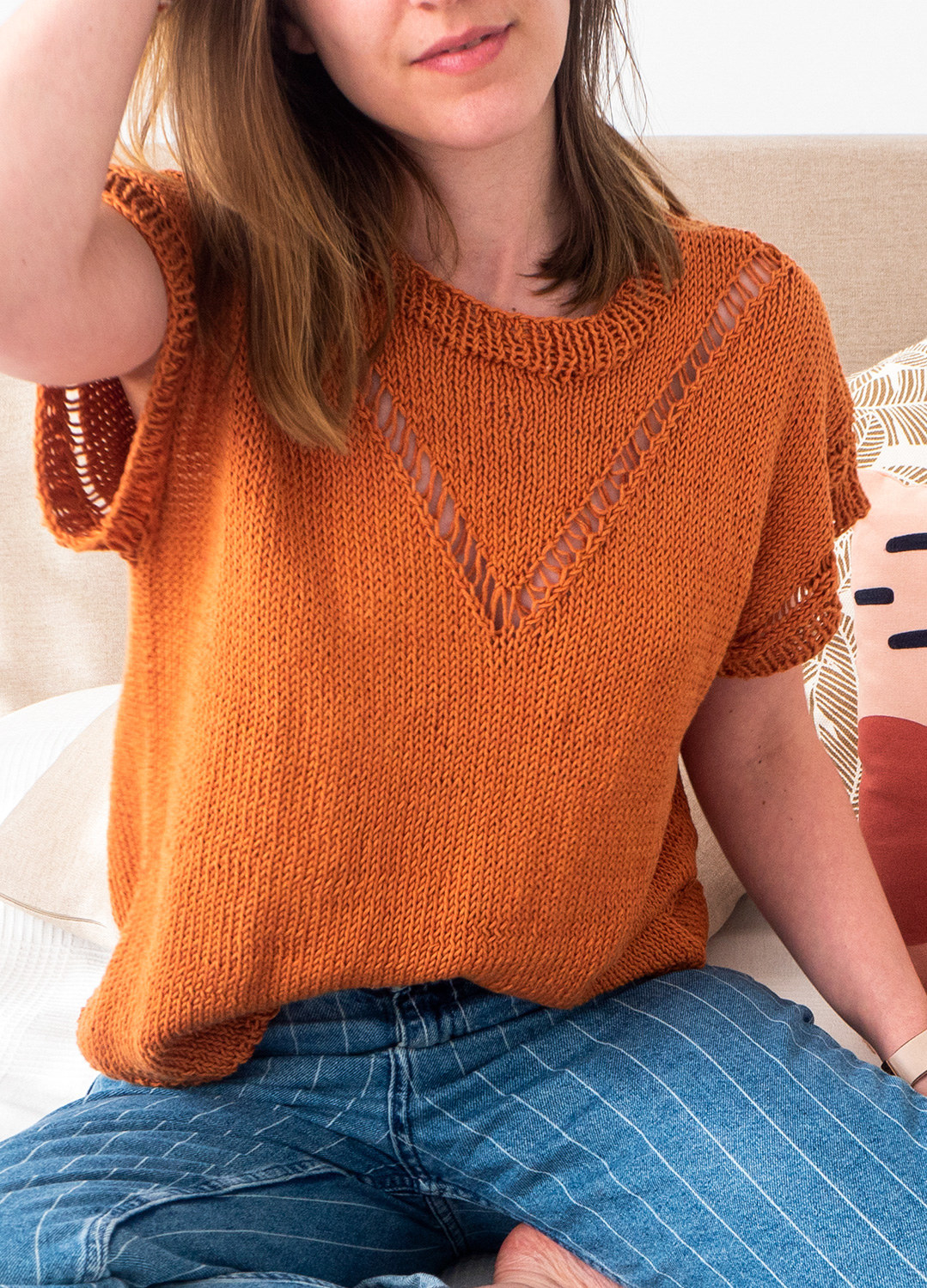 person wearing a boxy fit short sleeve knitted top