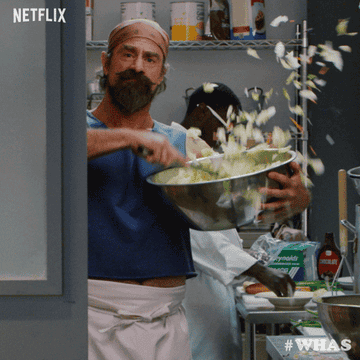 Christopher Meloni in the series &quot;wet hot american summer: first day of camp&quot; tossing a salad in a large bowl, spilling it everywhere