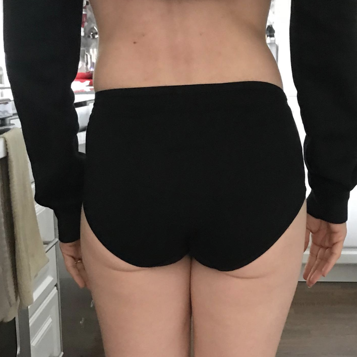 The same reviewer showing the back of the underwear which sit at the top of the hips and cover the butt