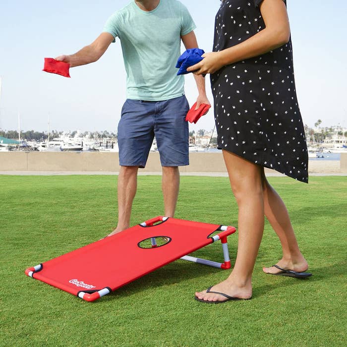 Two people playing cornhole