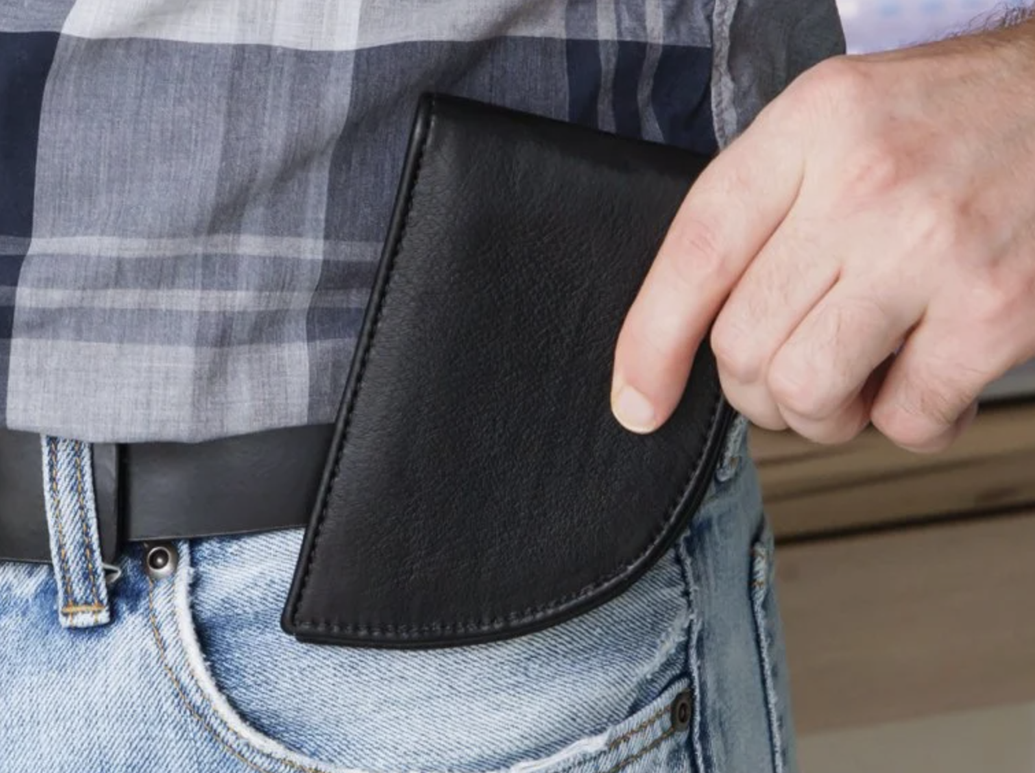 The curved wallet being put in a pocket 