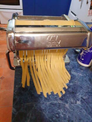 reviewer pic of fettuccine noodles coming out of pasta maker