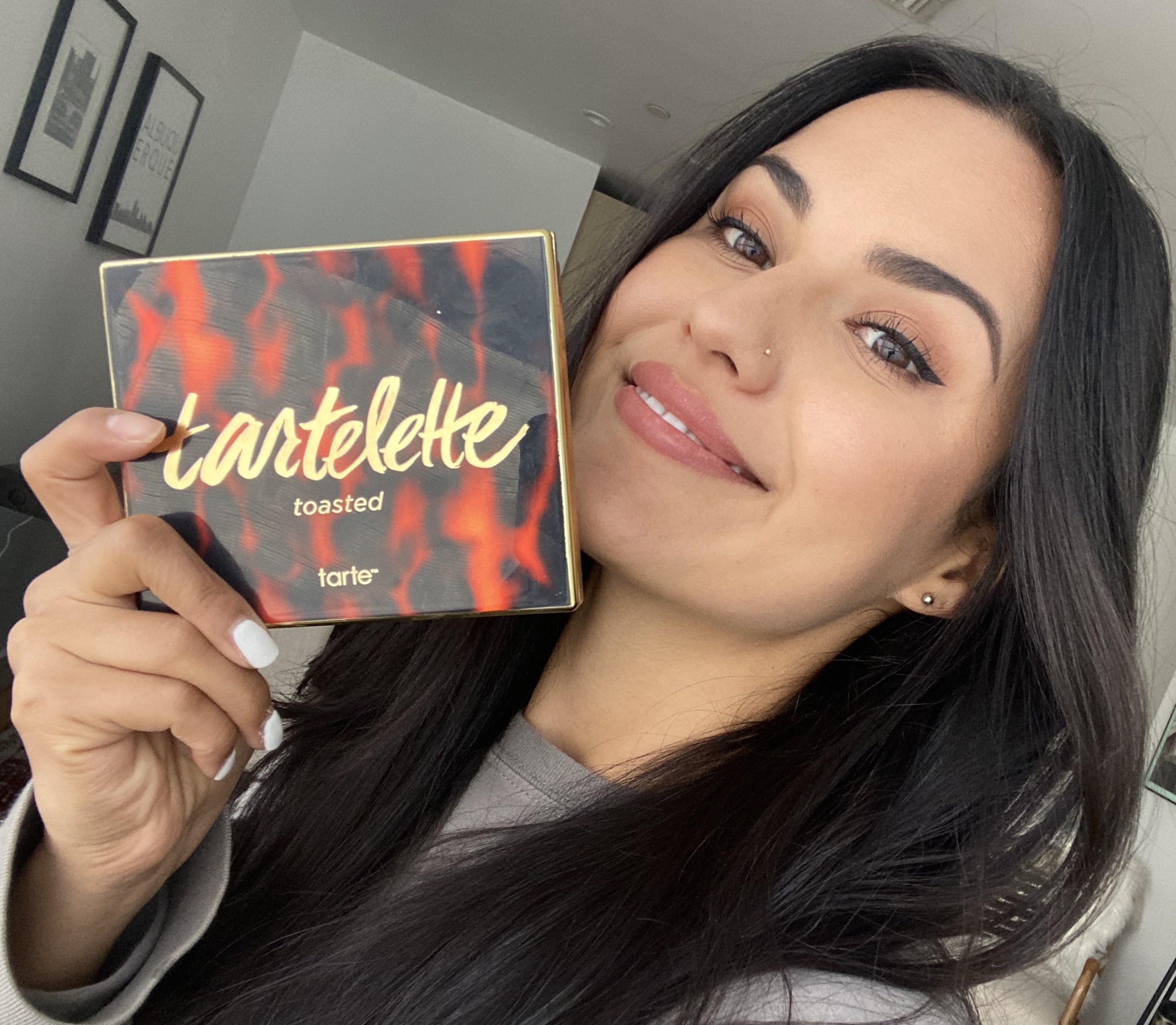 BuzzFeed Shopping reviewer holding the palette and wearing a tan smokey eye