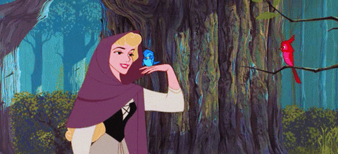 Aurora in the woods singing and releasing a blue bird on her hand