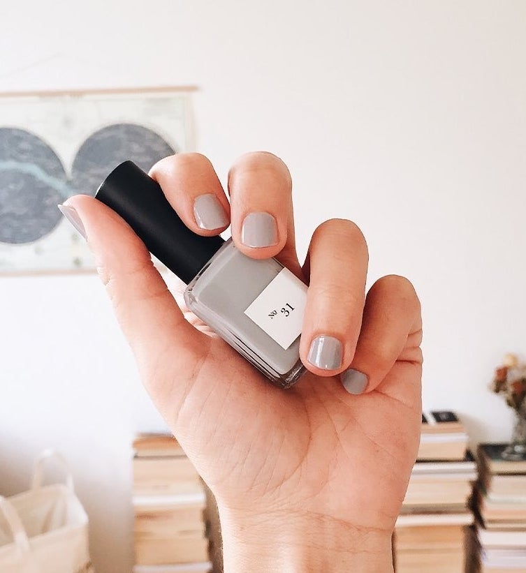 hand holding light purple nail polish bottle