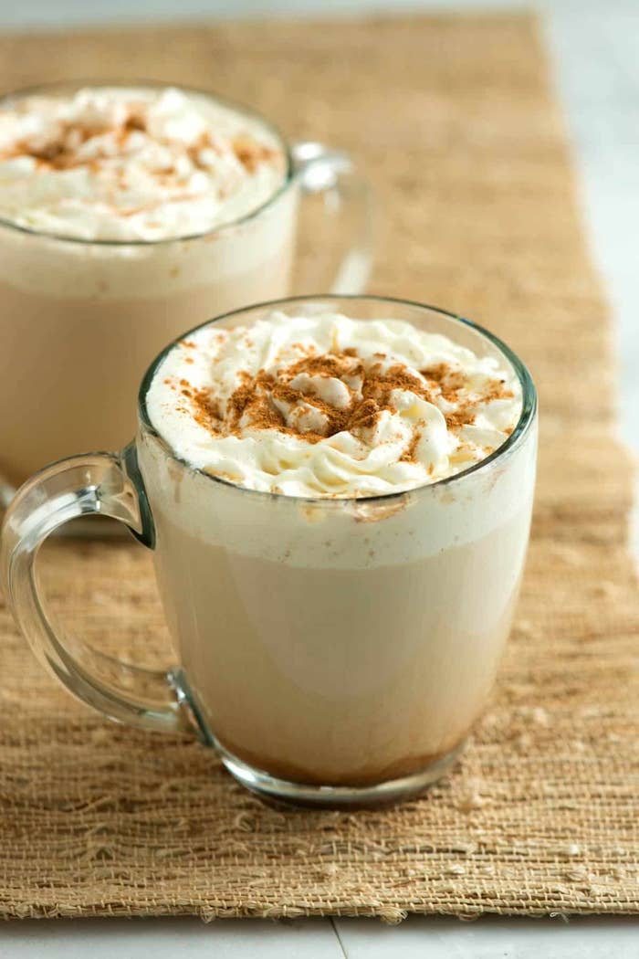 The latte in a glass jar topped with whipped cream and spice