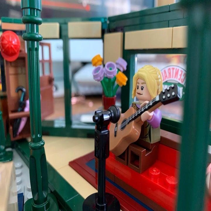 lego figure of phoebe at microphone holding a guitar 