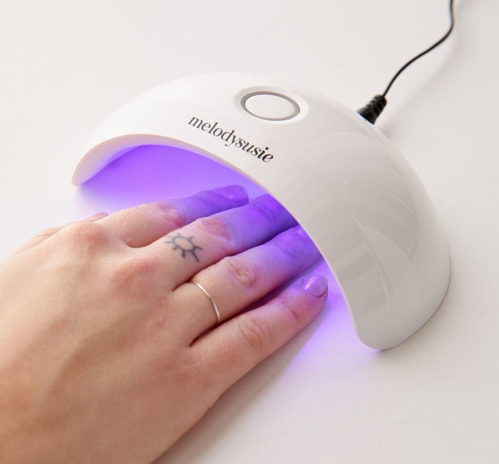 A model drying their nails under the lamp