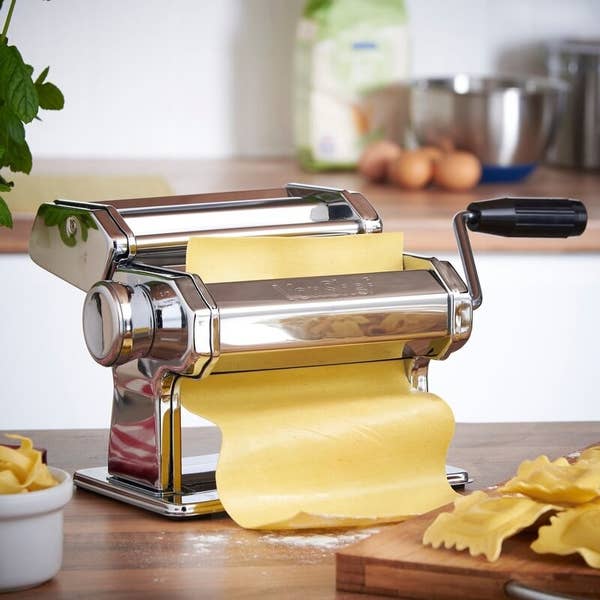 Fresh egg pasta being rolled in the pasta maker.