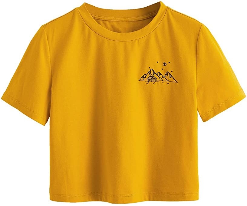 orange boxy T shirt with embroidery of mountain range, cabin, stars, moon