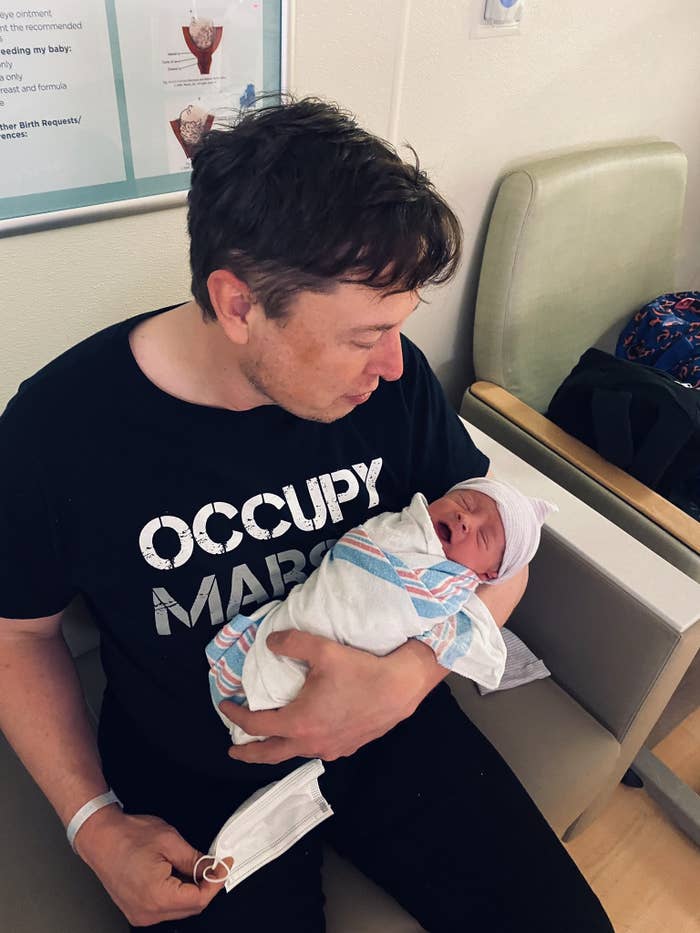 Elon Musk holds his newborn baby in a picture he posted on Twitter.