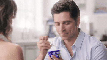 John Stamos eating yogurt (with a yogurt mustache) for a commercial.