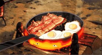 calicifer, the fire from howl&#x27;s moving castle, being fed egg shells while cooking bacon and eggs