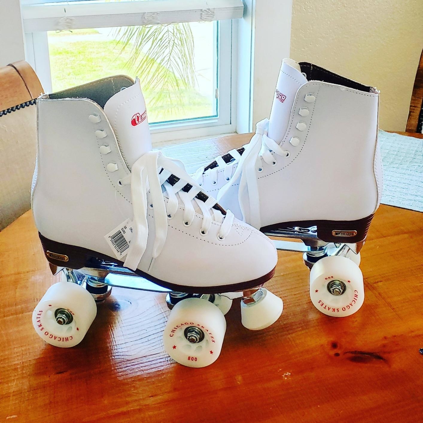 White roller skates with white wheels on a wooden table