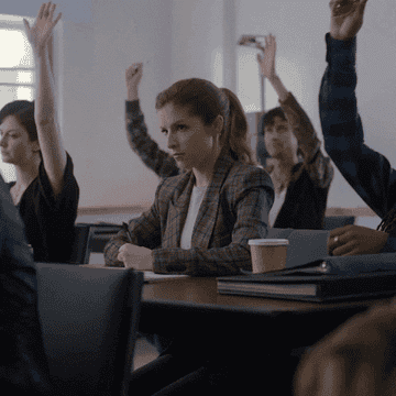 Gif of Anna Kendrick in her new HBO Max show, surrounded by people raising their hands