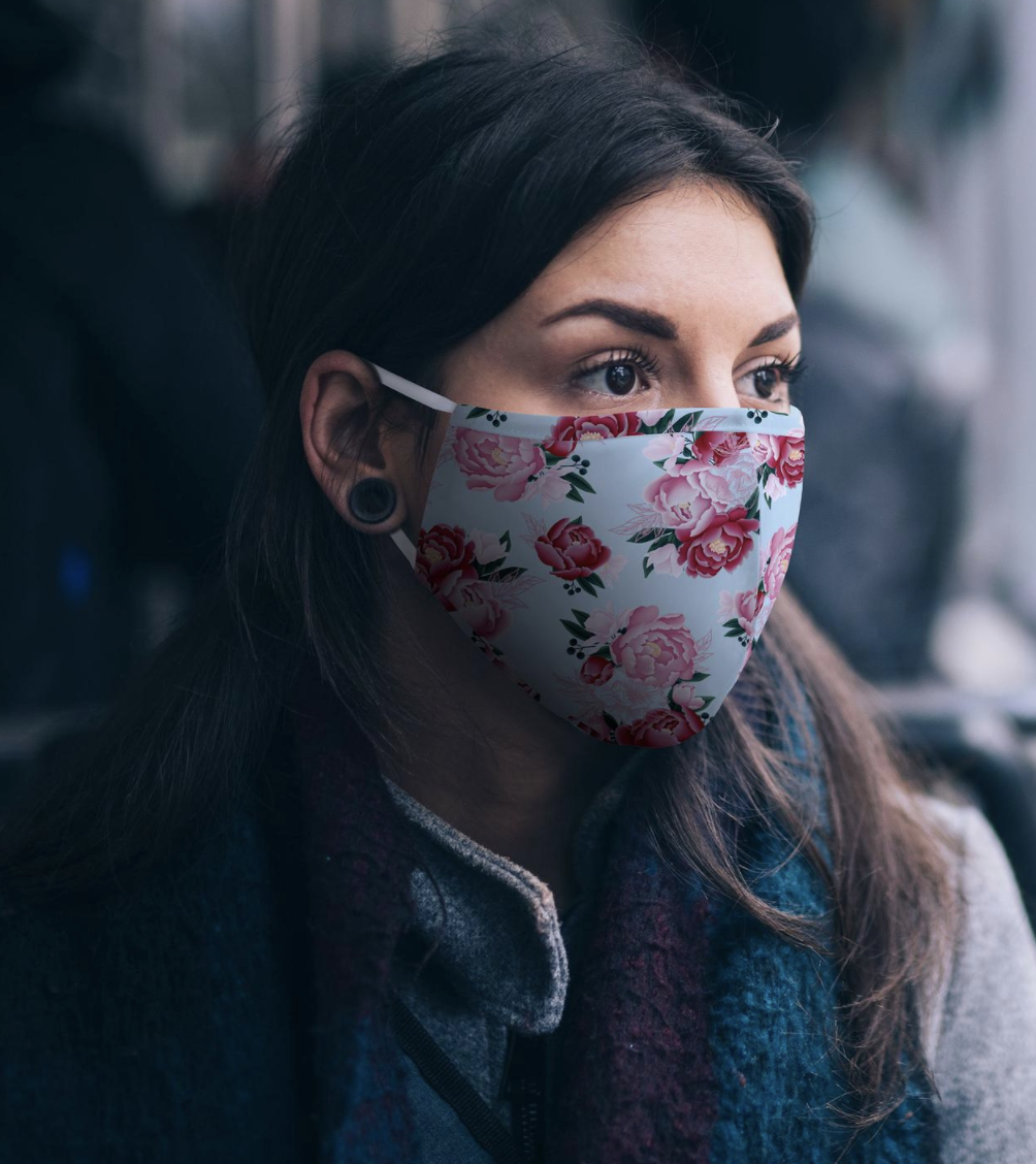 Model wears an embroidered floral face mask on their face