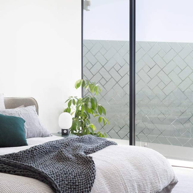 Bedroom with the privacy film with a rectangle design on a large window