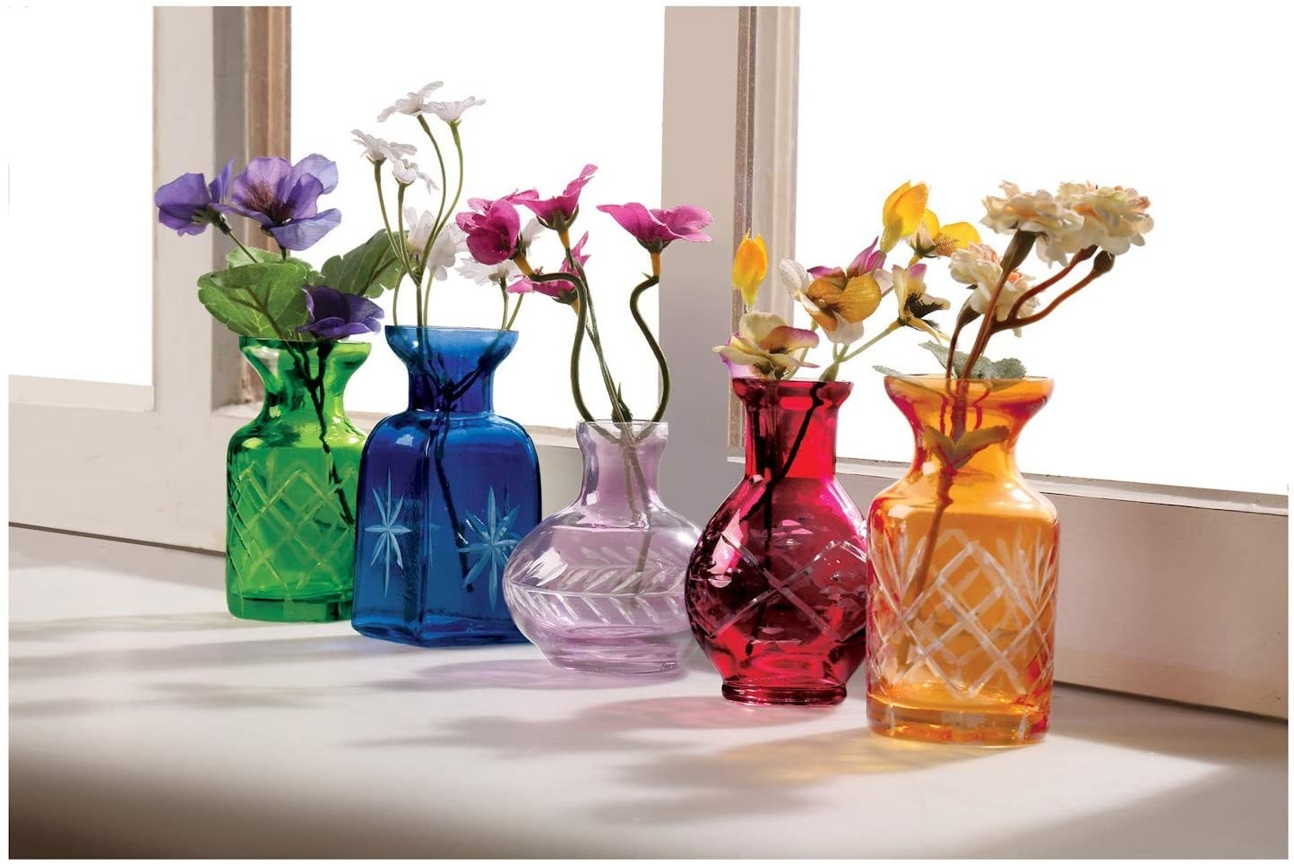 Five small glass vases in different sizes with etching on the bases in green, blue, purples, red, and orange