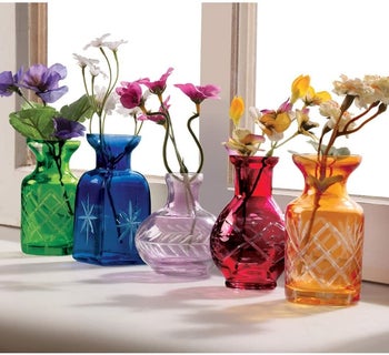 Five small glass vases in different sizes with etching on the bases in green, blue, purples, red, and orange