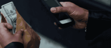 亚当•桑德勒在“未雕琢的Gems"采取现金和手机闪光灯的照片