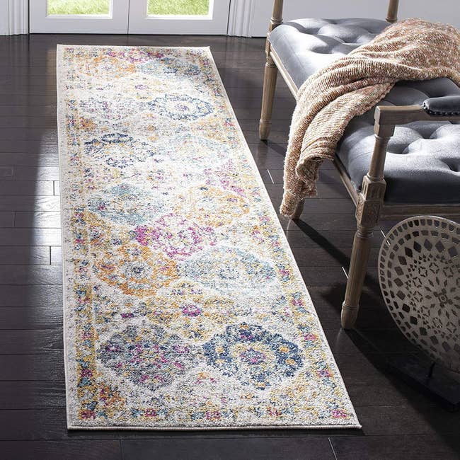 The rectangular runner with multi-color diamond-like pattern and border around it in a house