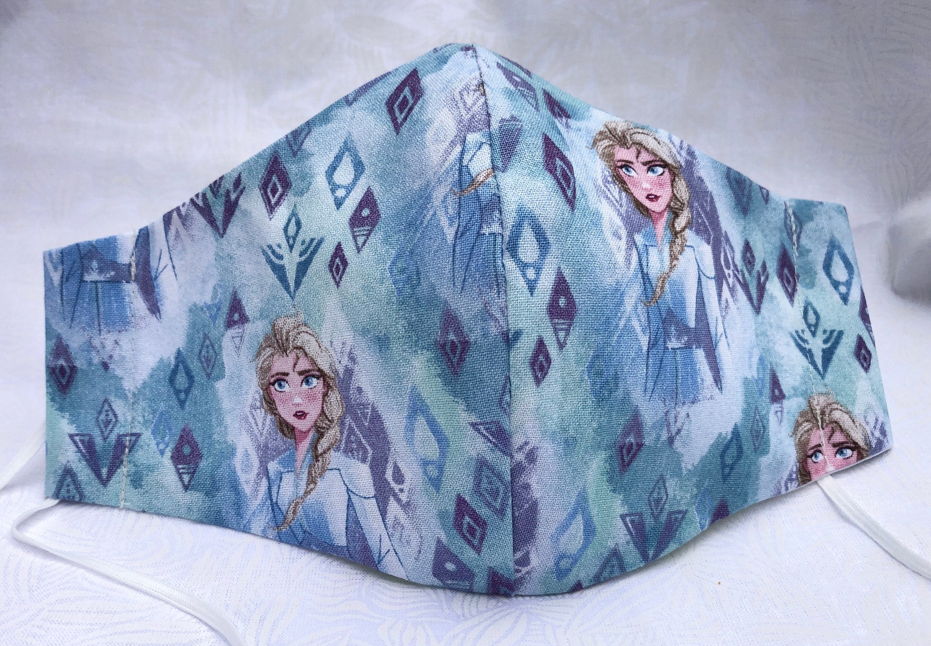 a light blue watercolored-like mask with elsa on it