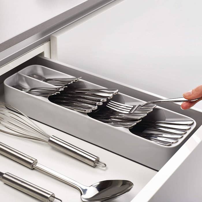 A rectangular silverware organizer that fits neatly into the side of a drawer