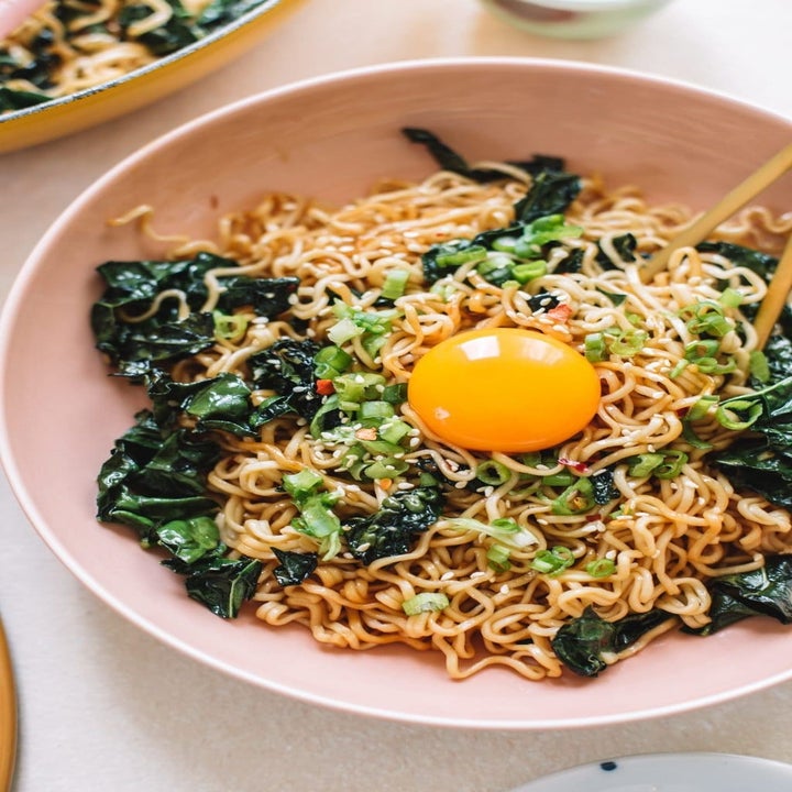 Ramen stir fry with kale and an egg yolk on top.