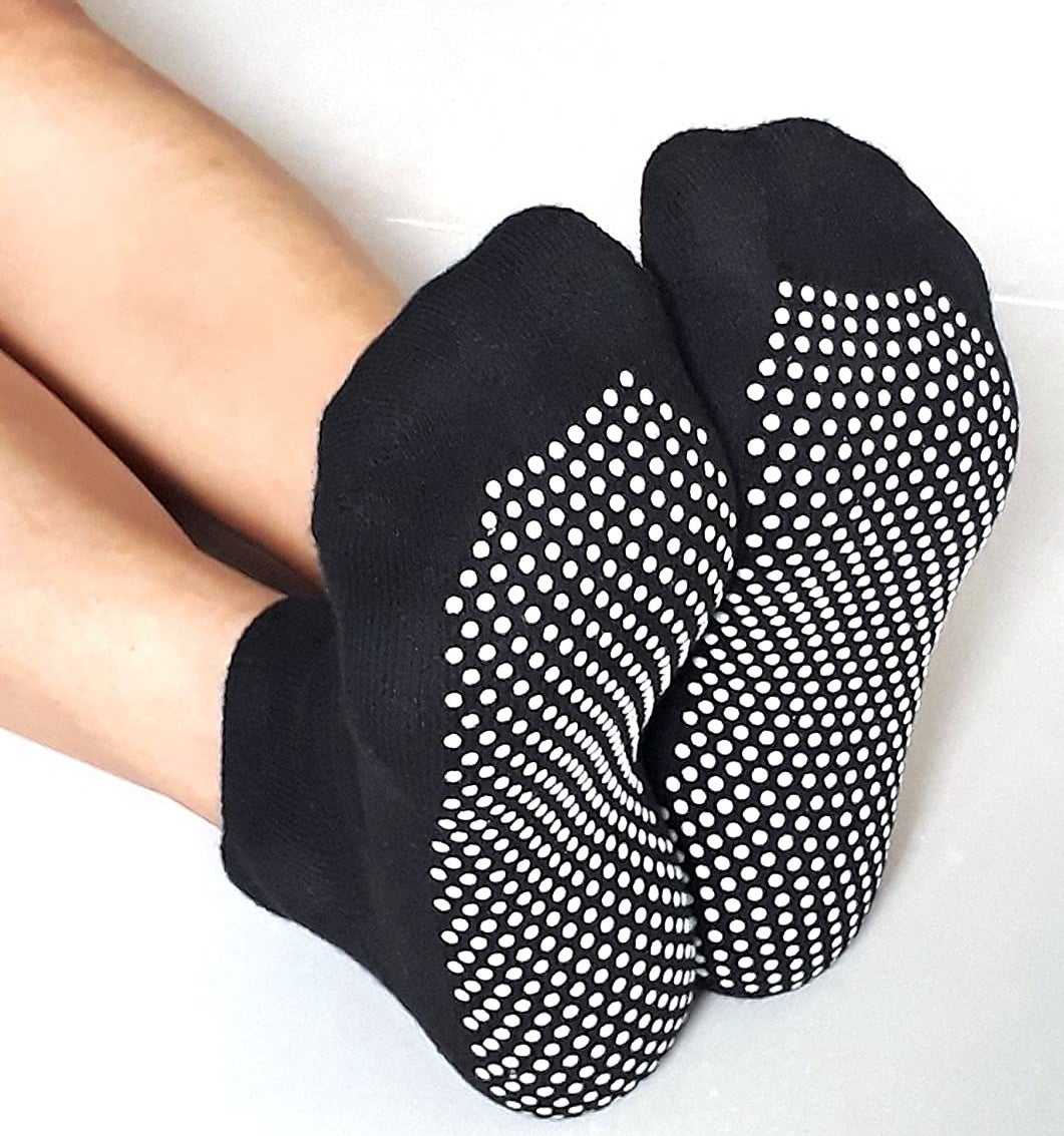 feet in black socks with white grips on the bottom 