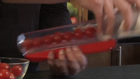 Gif of hand slicing cherry tomatoes with the slicer 
