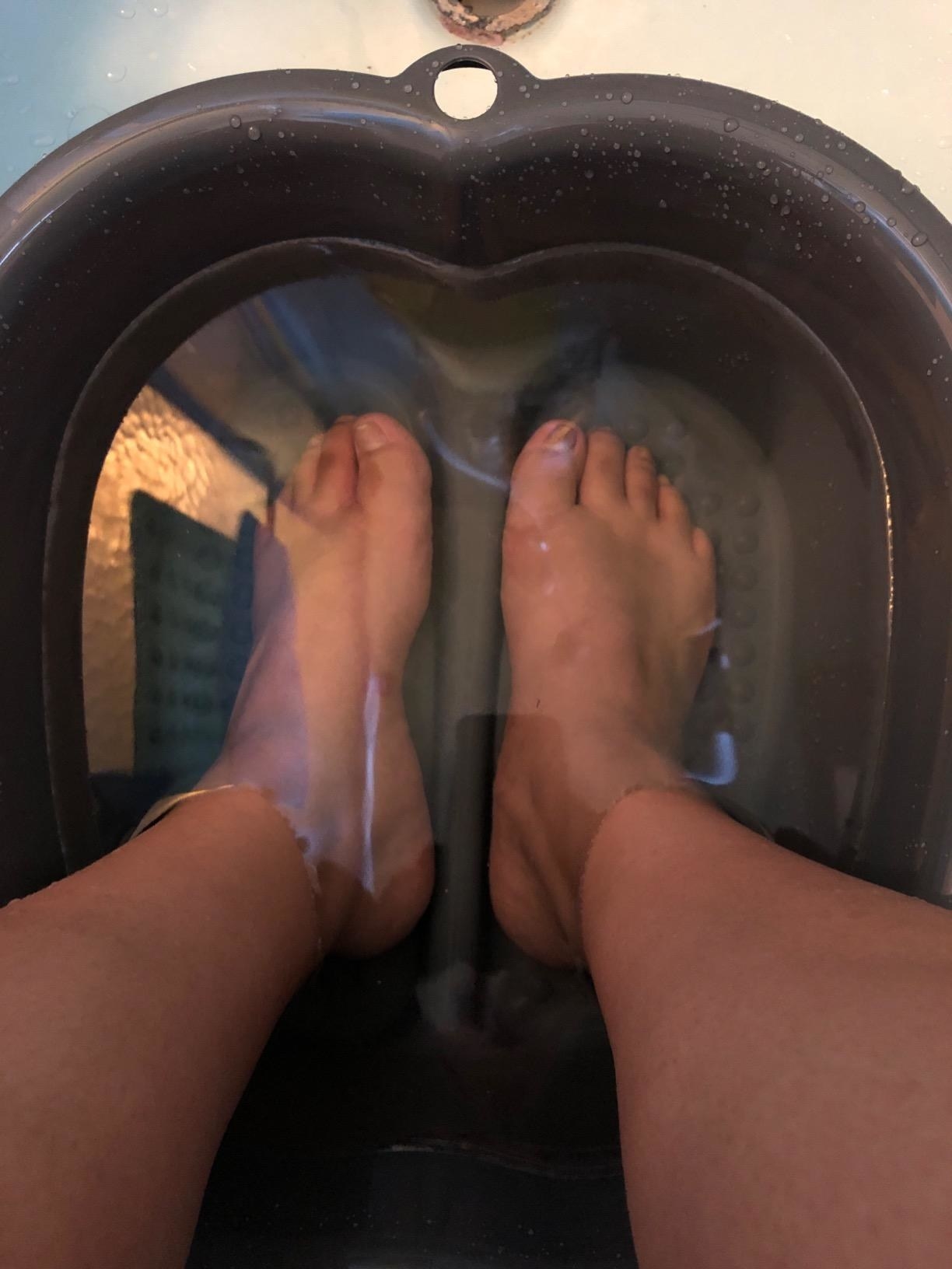 A reviewer with their feet inside the basin filled with water