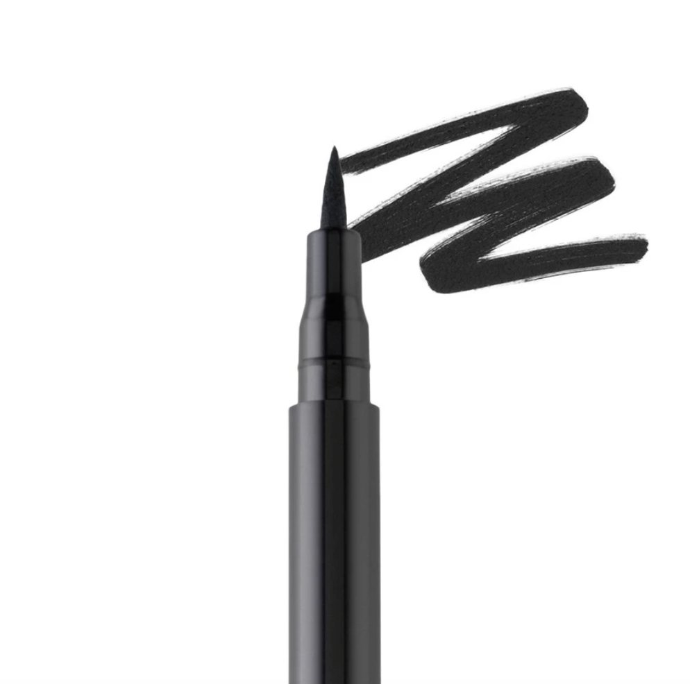 A closeup of the eyeliner tip next to a streak of eyeliner on a surface 