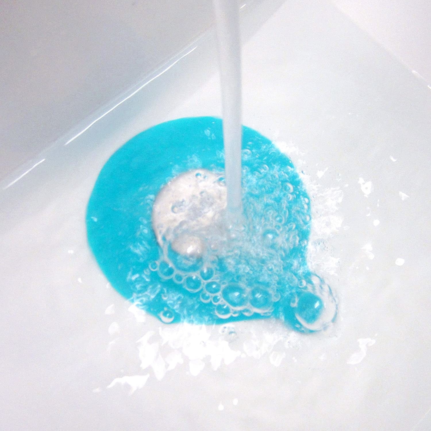 a blue tub stopper underneath a running water faucet