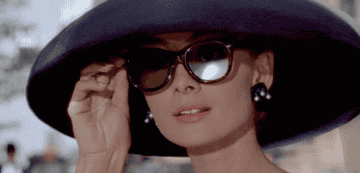 Audrey Hepburn lowering her sunglasses 