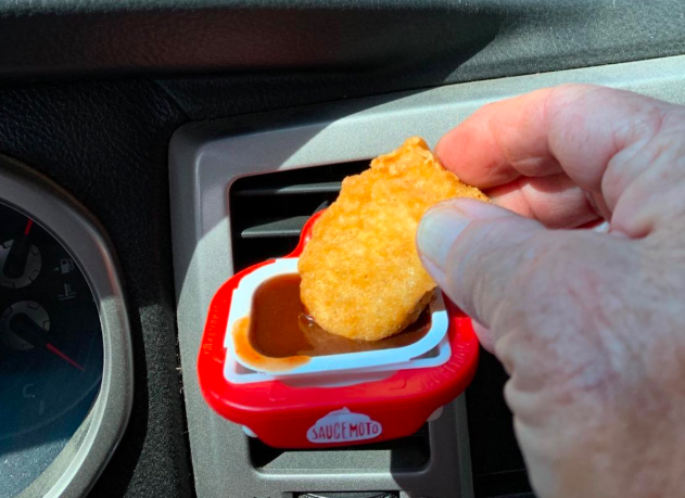A customer review photo of them using the dip clip attached to their car vent