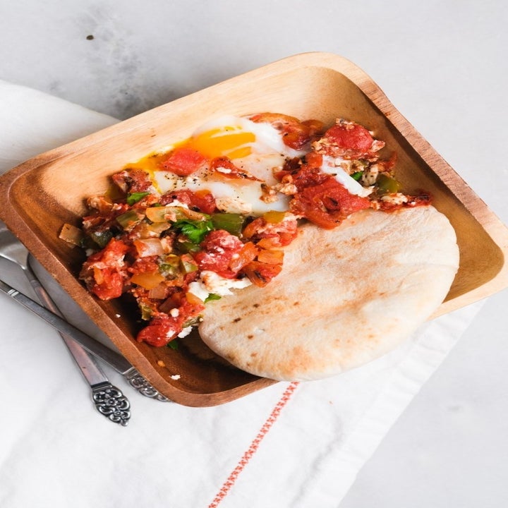 A bowl of shakshuka with pita bread.