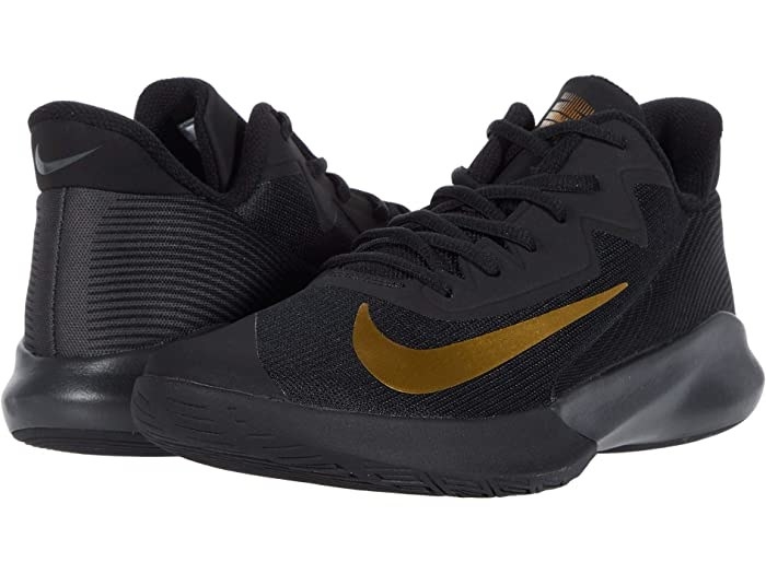 all black high-top mesh sneakers with laces, a tongue, and a big metallic gold Nike swoosh logo on the foot