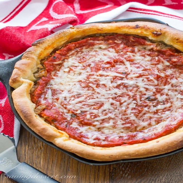 A deep dish pizza pie with tomato sauce and cheese.