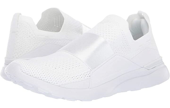 All-white shoes with mesh on the top and a stretch band across the center of the foot