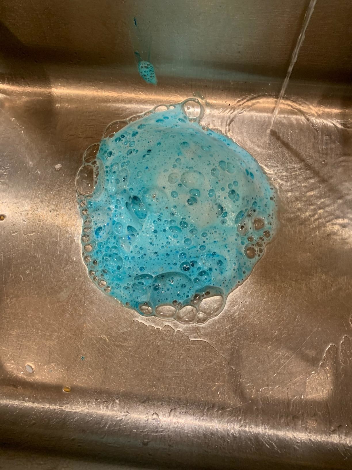 A reviewer&#x27;s sink with blue foam bubbling out of the drain