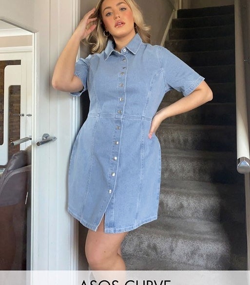 model wears a structured denim dress with buttons down the front 