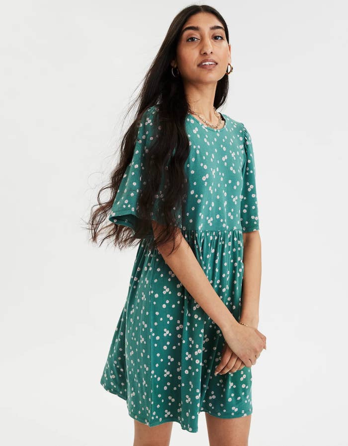 a model wears the dress in green with tiny white flowers 