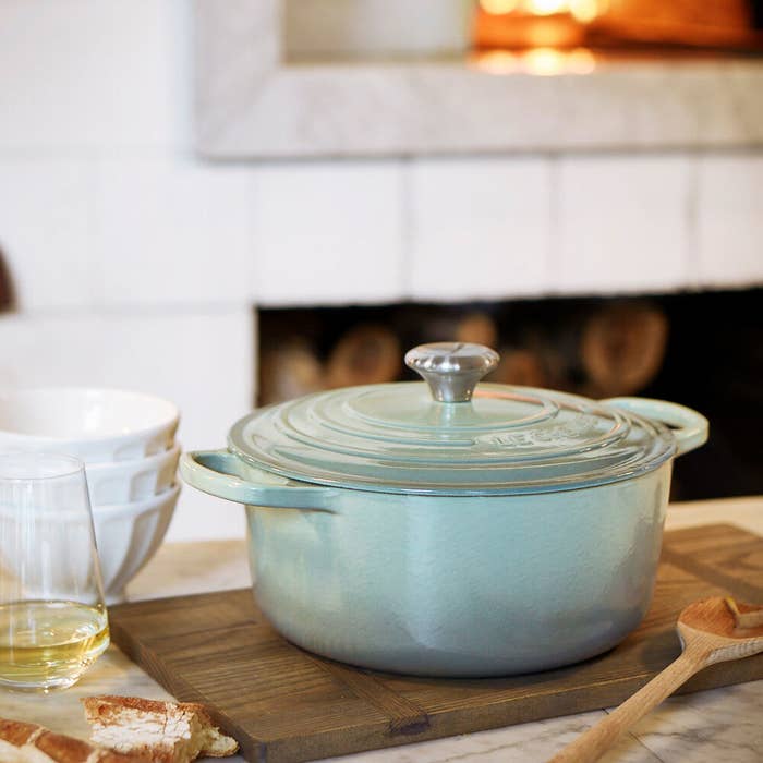 a pale blue dutch oven with handles on each side and a heavy duty lid 