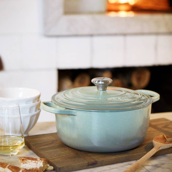 a pale blue dutch oven with handles on each side and a heavy duty lid