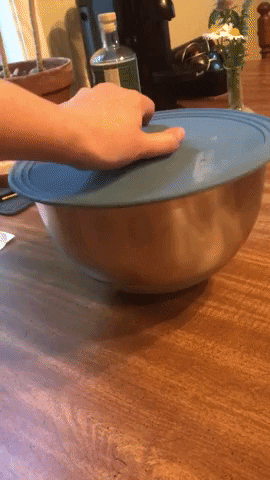 gif of writer&#x27;s hand picking up a bowl by the lid&#x27;s handle, then flipping it open to reveal cookie dough