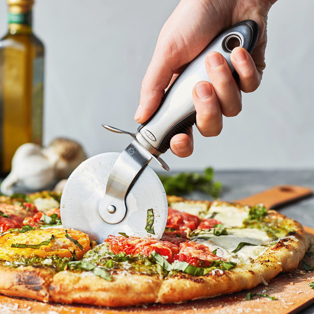 the stainless steel pizza wheel cutting into a pizza